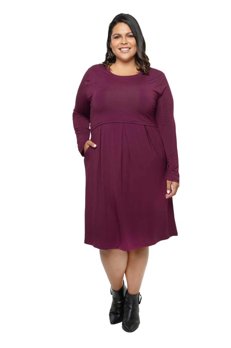 Curvy plus size brunette model wearing burgundy Robyn breastfeeding dress with one hand in her pocket. Sizes 6 - 26