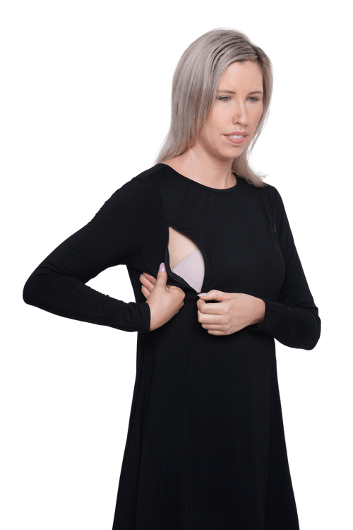 Petite model facing camera wearing black A-line swing dress, featuring rounded neckline. Amber available in sizes 6-26