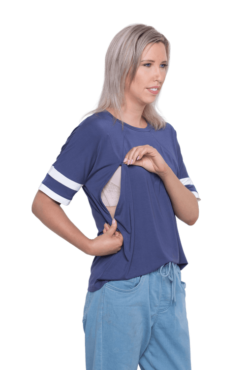 Petite model facing camera wearing navy blue, short sleeved, relaxed fit top, features rounded neckline and two white varsity stripes on the sleeve. Cameron available in sizes 6-26