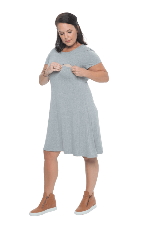 Model facing camera wearing grey, short sleeved, knee length, A-line dress. Features rounded neckline. Emma available in sizes 6-18