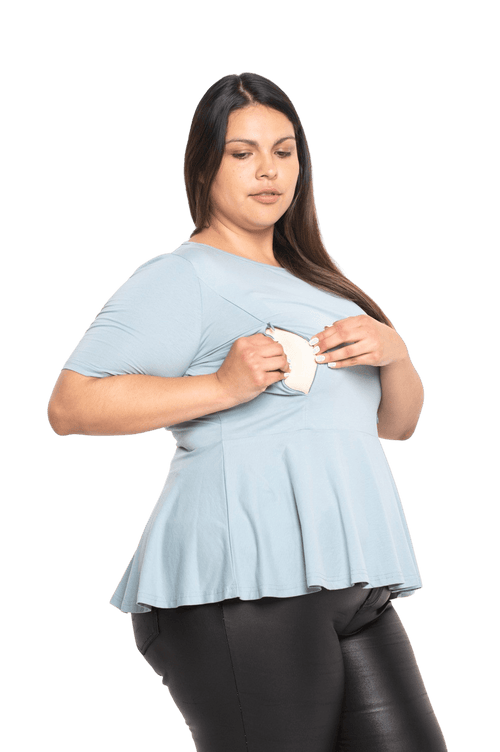 Curvy model facing camera wearing light blue short sleeved top. Featuring rounded neckline and peplum tier under bust. Isla available in sizes 6-26