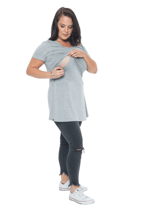 Model facing camera wearing grey, short sleeved top. Features rounded neckline. Jade available in sizes 6-18