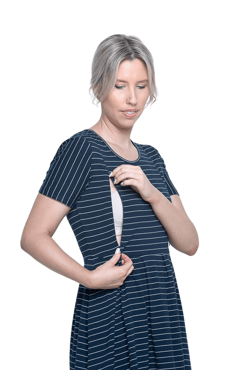 Curvy model facing camera wearing navy with white pin striped, knee length dress, featuring rounded neckline, fitted bodice, pleated A-line skirt and pockets. Kaitlyn available in sizes 6-26