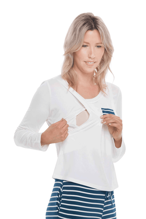 Petite model facing the camera wearing long sleeved pyjamas with pants. Top is white with contrast breast pocket matching pants. Pants are teal and white stripe, featuring pockets, and elasticated waist with pull tie. Piper available in sizes 6-18