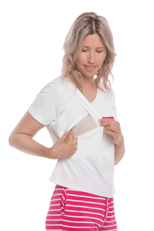 Petite model facing the camera wearing short sleeved pyjamas with shorts. Top is white with contrast breast pocket matching shorts. Shorts are hot pink and white stripe, featuring pockets, and elasticated waist with pull tie. Poppy available in sizes 6-18