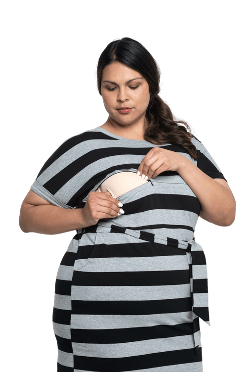 Petite model facing camera wearing charcoal grey and black striped t-shirt dress, featuring rounded neckline, pockets, belt feature, and capped sleeves. Quinn available in sizes 6-26