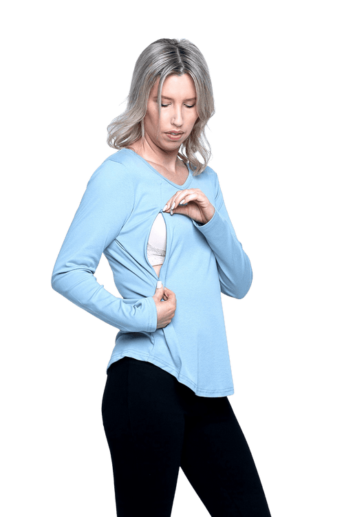 Curvy model facing camera wearing dusty blue long sleeved top, featuring soft V-neck and a scooped hem. Reese available in sizes 6-26