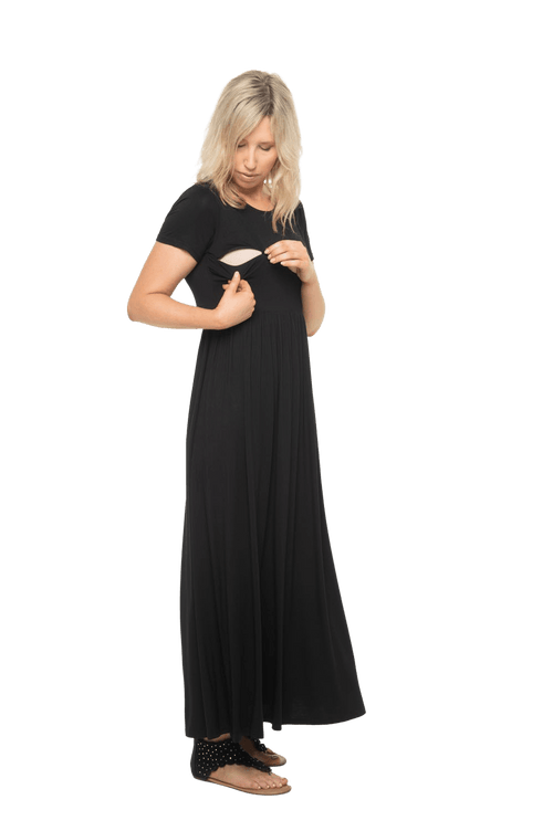 Curvy model facing camera wearing black maxi dress, featuring  rounded neckline, and a gently fitted bodice, gathering above the waist. Riley available in sizes 6-26