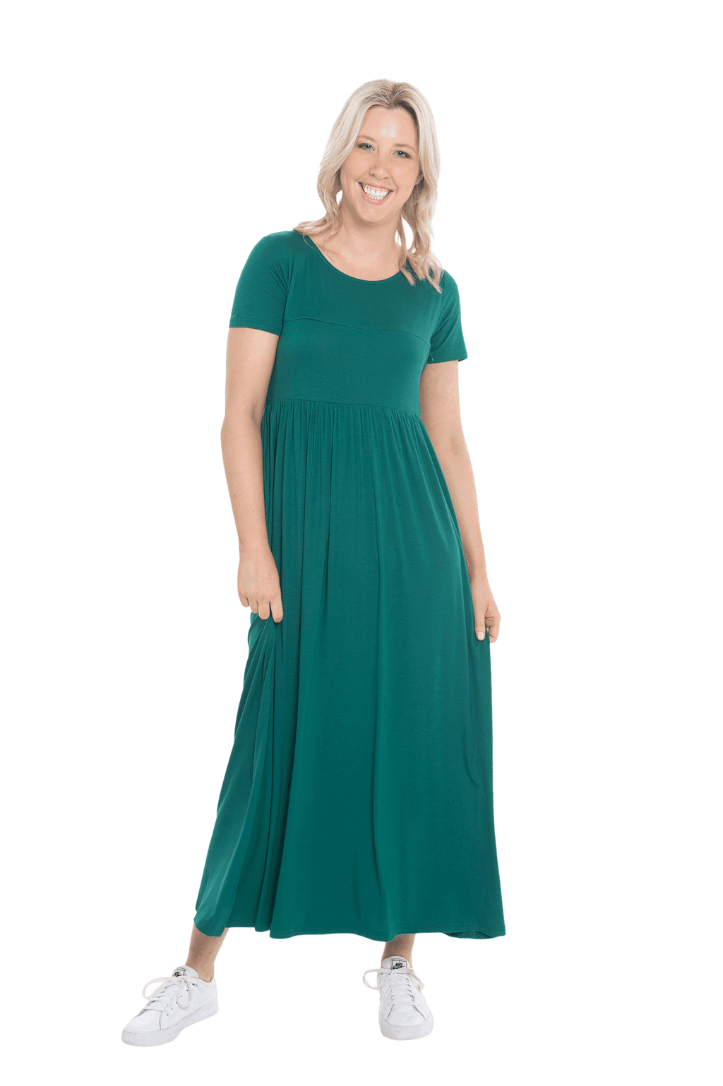 Petite model facing the camera wearing bottle green maxi dress, featuring  rounded neckline, and a gently fitted bodice, gathering above the waist. Riley available in sizes 6-26