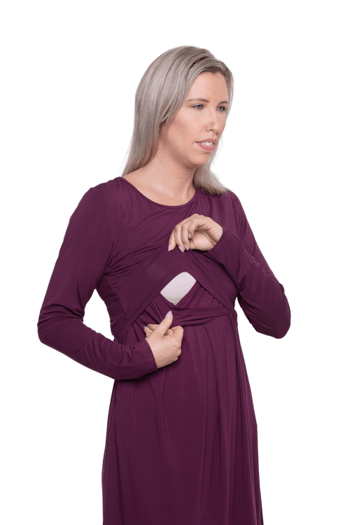 Curvy model facing camera wearing long sleeved, knee length burgundy dress. Featuring pockets, a rounded neckline, and pleated front. Robyn available in sizes 6-26