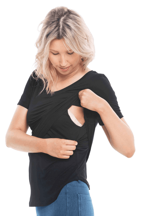 Petite model facing the camera wearing black short sleeved tee, featuring rounded neckline, and scooped hem. Stevie available in sizes 6-26