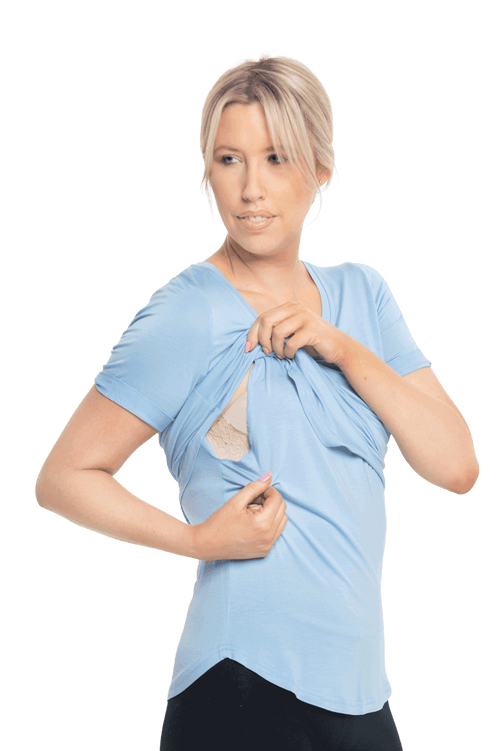 Petite model facing the camera wearing light blue short sleeved tee, featuring rounded neckline, and scooped hem. Stevie available in sizes 6-18