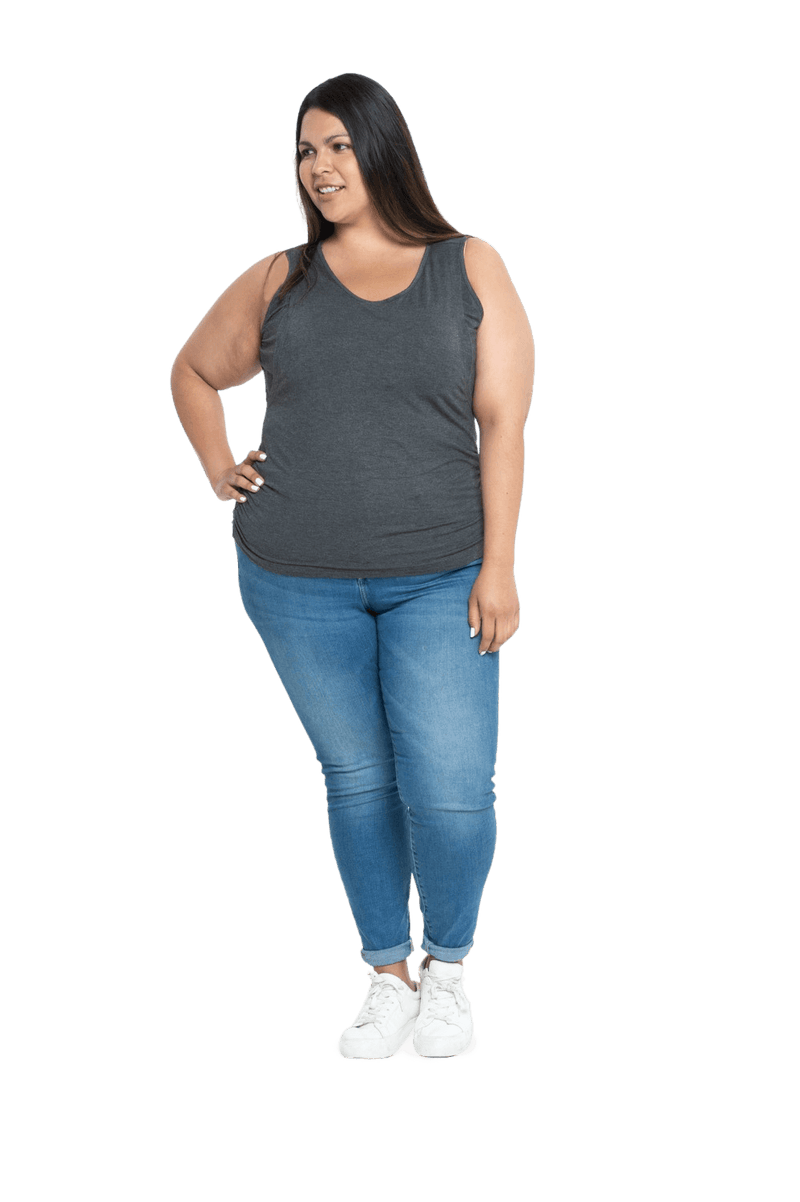 Curvy model facing camera wearing charcoal grey tank top, featuring rounded neckline and side rouching. Adrien available in sizes 6-26