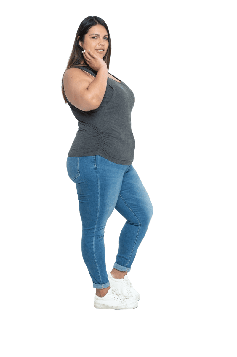 Curvy model facing side wearing charcoal grey tank top, featuring rounded neckline and side rouching. Adrien available in sizes 6-26