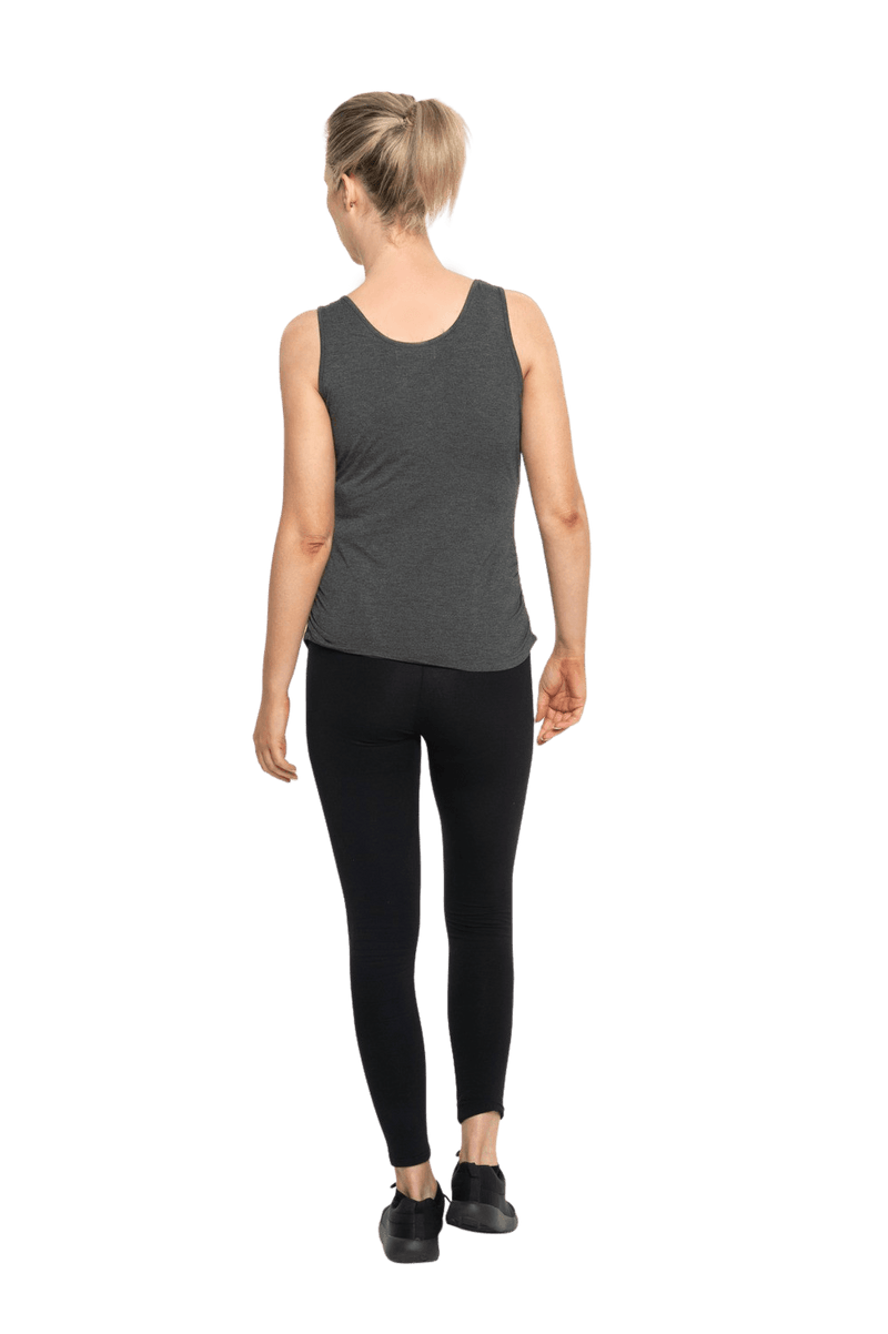 Petite model facing the back wearing charcoal grey tank top, featuring rounded neckline and side rouching. Adrien available in sizes 6-26