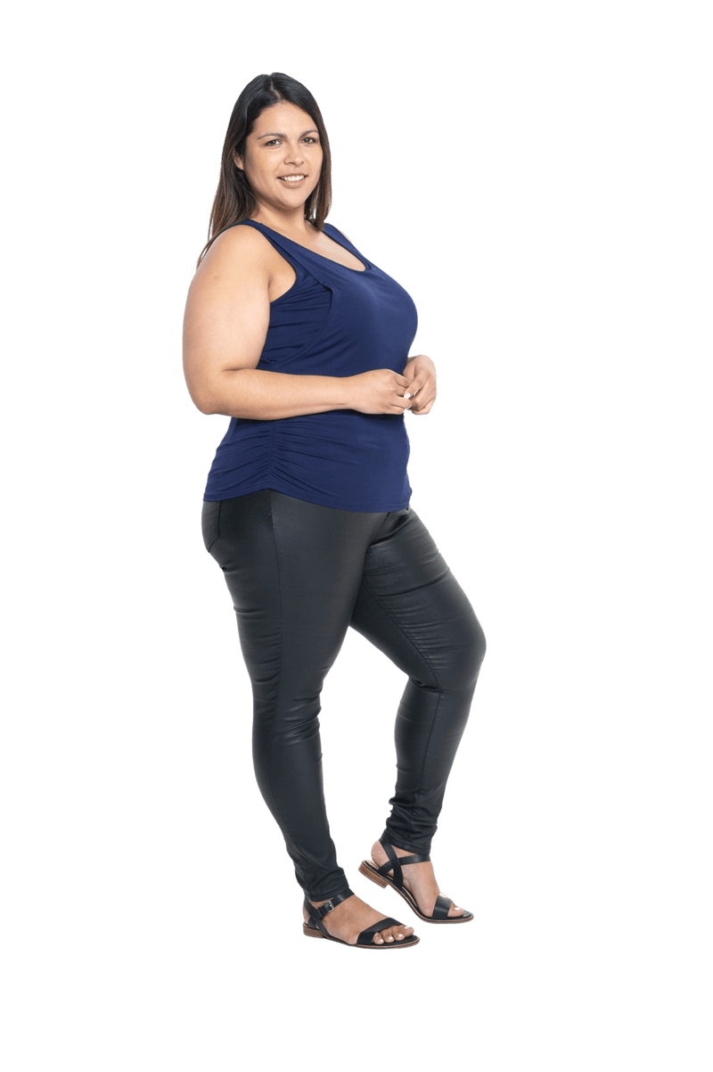 Curvy model facing side wearing navy blue tank top, featuring rounded neckline and side rouching. Adrien available in sizes 6-26