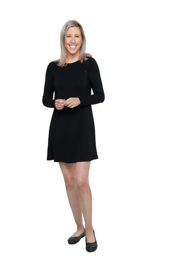 Petite model facing camera wearing black A-line swing dress, featuring rounded neckline. Amber available in sizes 6-26