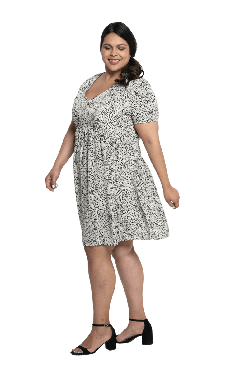 Curvy model facing the side wearing knee length, leopard print dress, featuring soft v-neck. Avery available in sizes 6-26