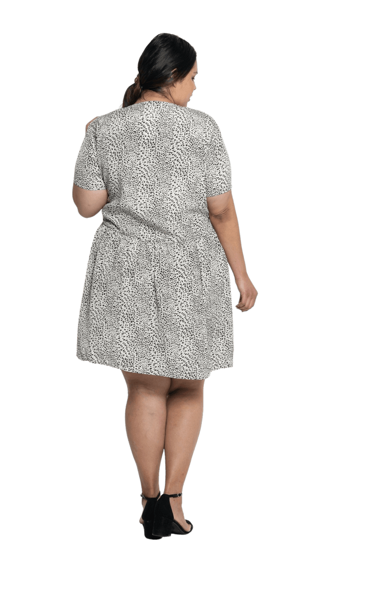 Curvy model facing the back wearing knee length, leopard print dress, featuring soft v-neck. Avery available in sizes 6-26