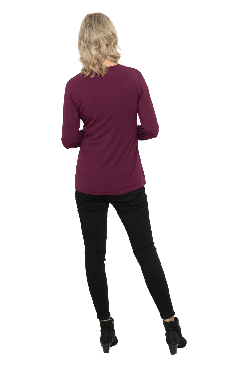 Petite model facing the back wearing burgundy, long sleeved, v-neck top, features small tie front under bust. Billie available in sizes 6-26