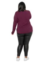 Curvy model facing the back wearing burgundy, long sleeved, v-neck top, features small tie front under bust. Billie available in sizes 6-26