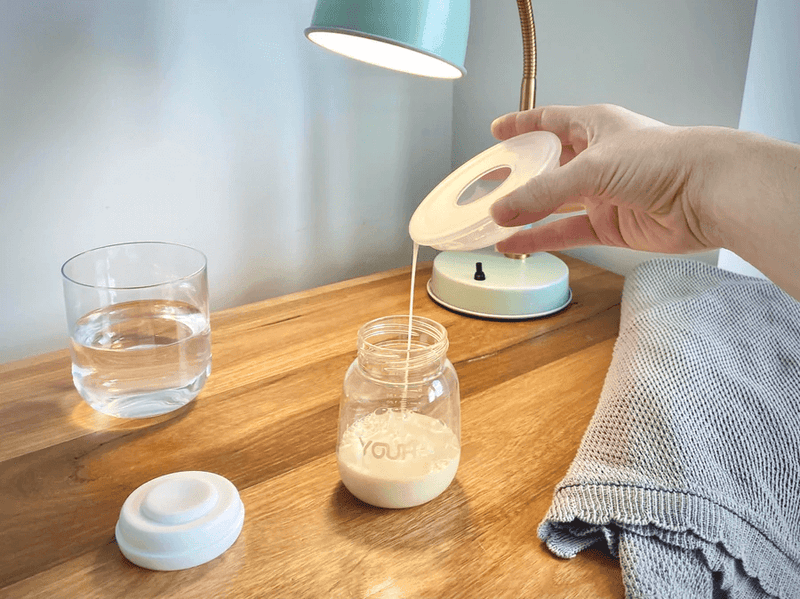 Pouring milk from breastmilk collection shell into bottle