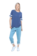 Petite model facing camera wearing navy blue, short sleeved, relaxed fit top, features rounded neckline and two white varsity stripes on the sleeve. Cameron available in sizes 6-26