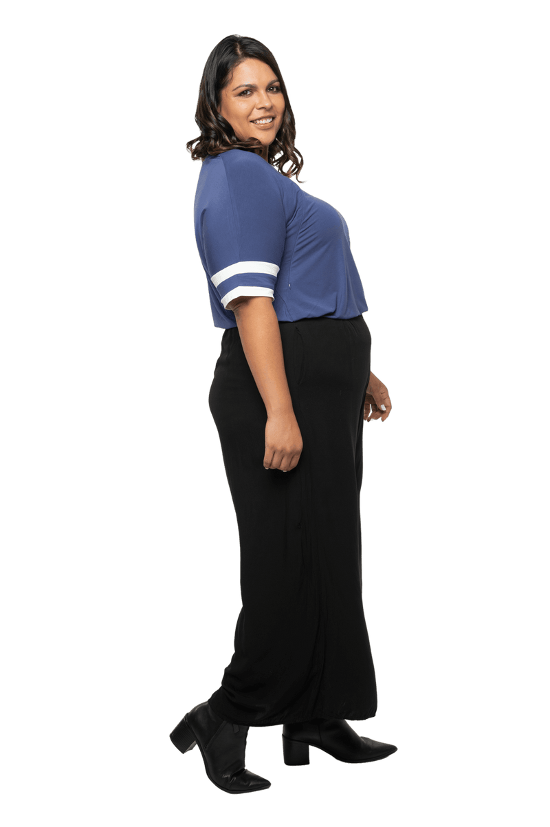 Curvy model facing the side wearing navy blue, short sleeved, relaxed fit top, features rounded neckline and two white varsity stripes on the sleeve. Cameron available in sizes 6-26