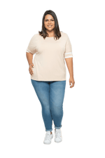 Curvy model facing camera wearing sand, short sleeved, relaxed fit top, features rounded neckline and two white varsity stripes on the sleeve. Cameron available in sizes 6-26