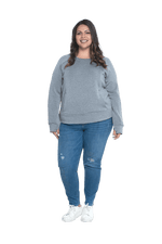 Curvy model facing camera wearing grey crew necked jumper, featuring thick, flat waist band, thumb holes, and pockets. Cassie available in sizes 6-26