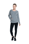 Petite model facing camera wearing grey crew necked jumper, featuring thick, flat waist band, thumb holes, and pockets. Cassie available in sizes 6-26