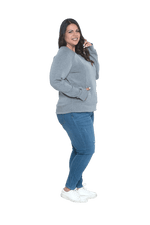 Curvy model facing the side wearing grey crew necked jumper, featuring thick, flat waist band, thumb holes, and pockets. Cassie available in sizes 6-26