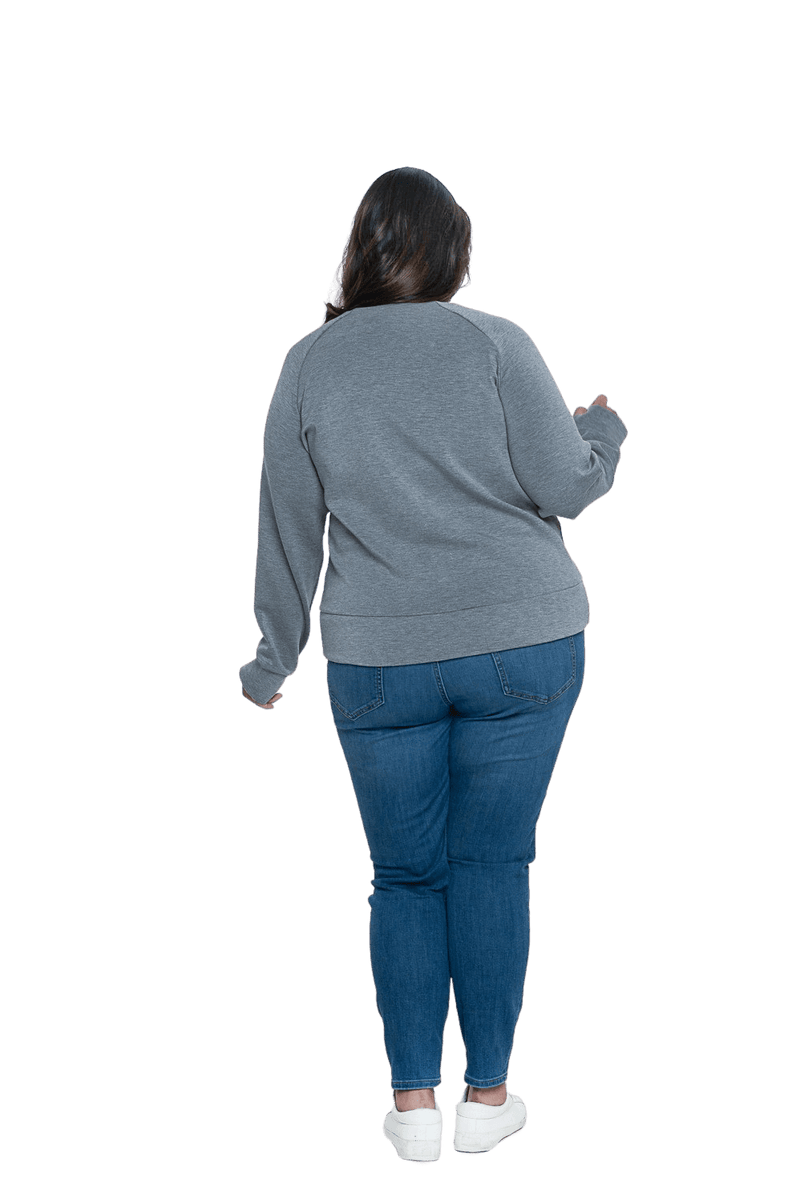 Curvy model facing the back wearing grey crew necked jumper, featuring thick, flat waist band, thumb holes, and pockets. Cassie available in sizes 6-26