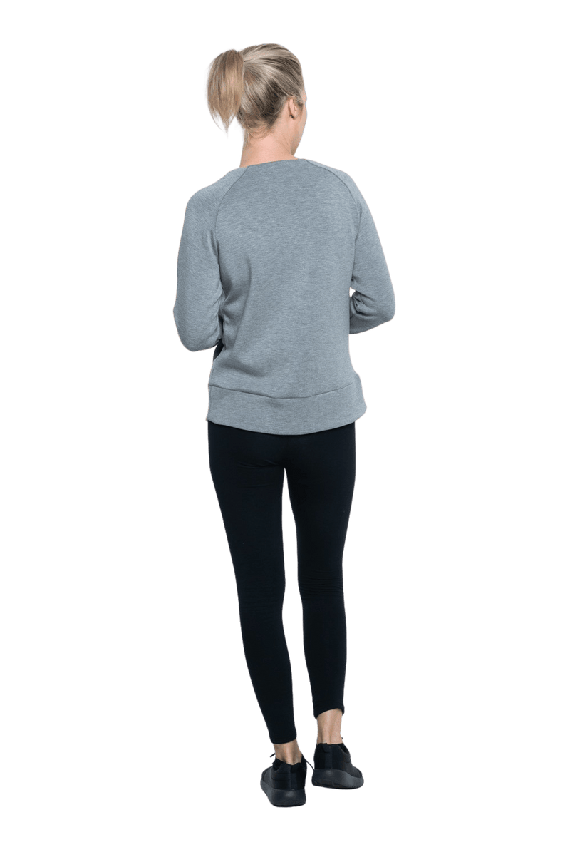 Petite model facing the back wearing grey crew necked jumper, featuring thick, flat waist band, thumb holes, and pockets. Cassie available in sizes 6-26