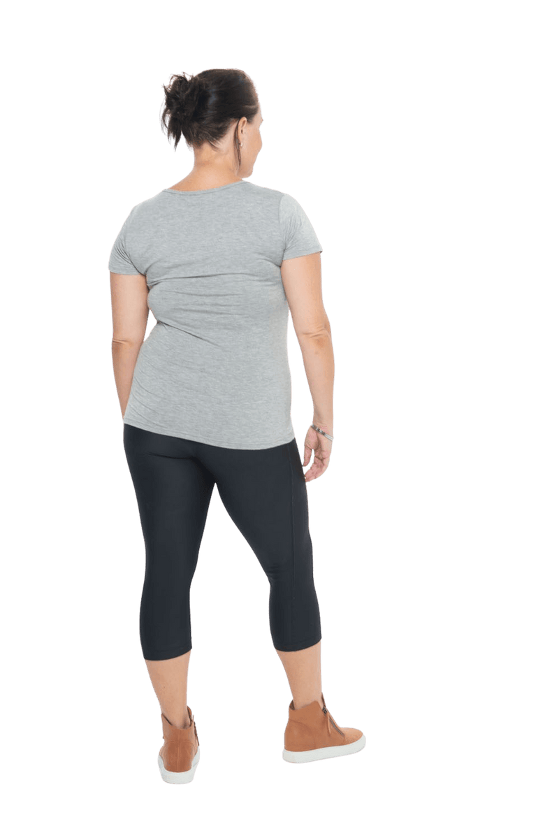 Model facing the back wearing grey, short sleeved tee, features rounded neckline. Cindy available in sizes 6-18