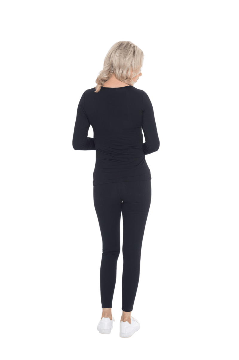 Petite model facing the back wearing black, long sleeved tee, features rounded neckline. Cindy available in sizes 6-26