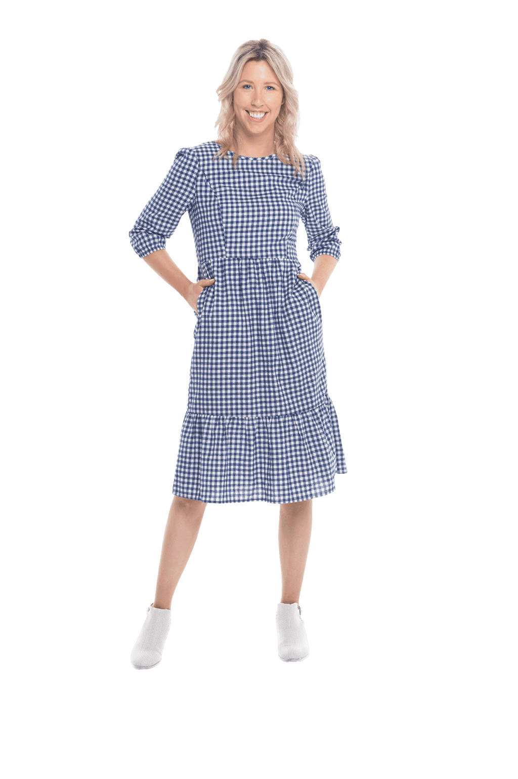 Model facing camera wearing blue gingham, mid-length sleeved midi dress, features rounded neckline, tiered skirt and pockets. Dorothy available in sizes 6-18