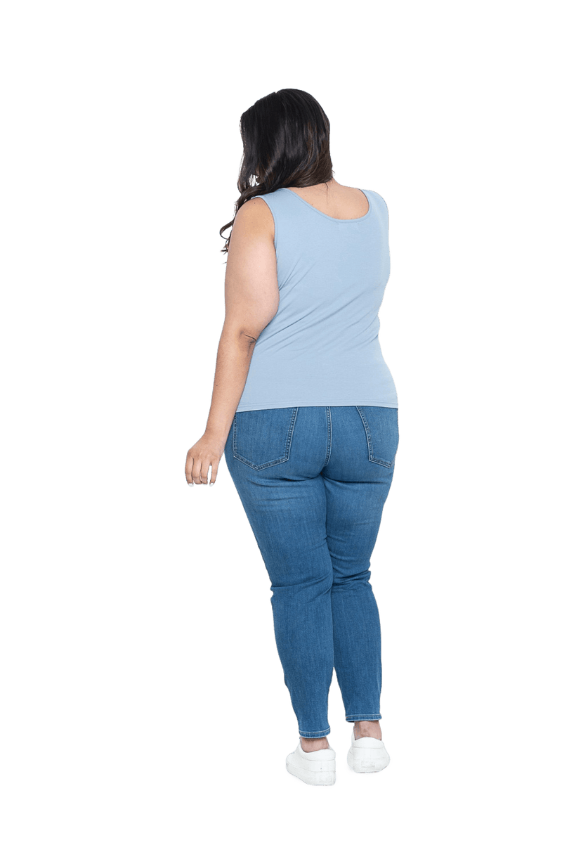 Curvy model facing the back wearing light blue tank top, features rounded neckline. Drew available in sizes 6-26