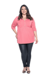 Curvy model facing camera wearing pink, mid-length sleeved top. Features button up v-neckline and peplum tier under bust. Dylan available in sizes 6-26