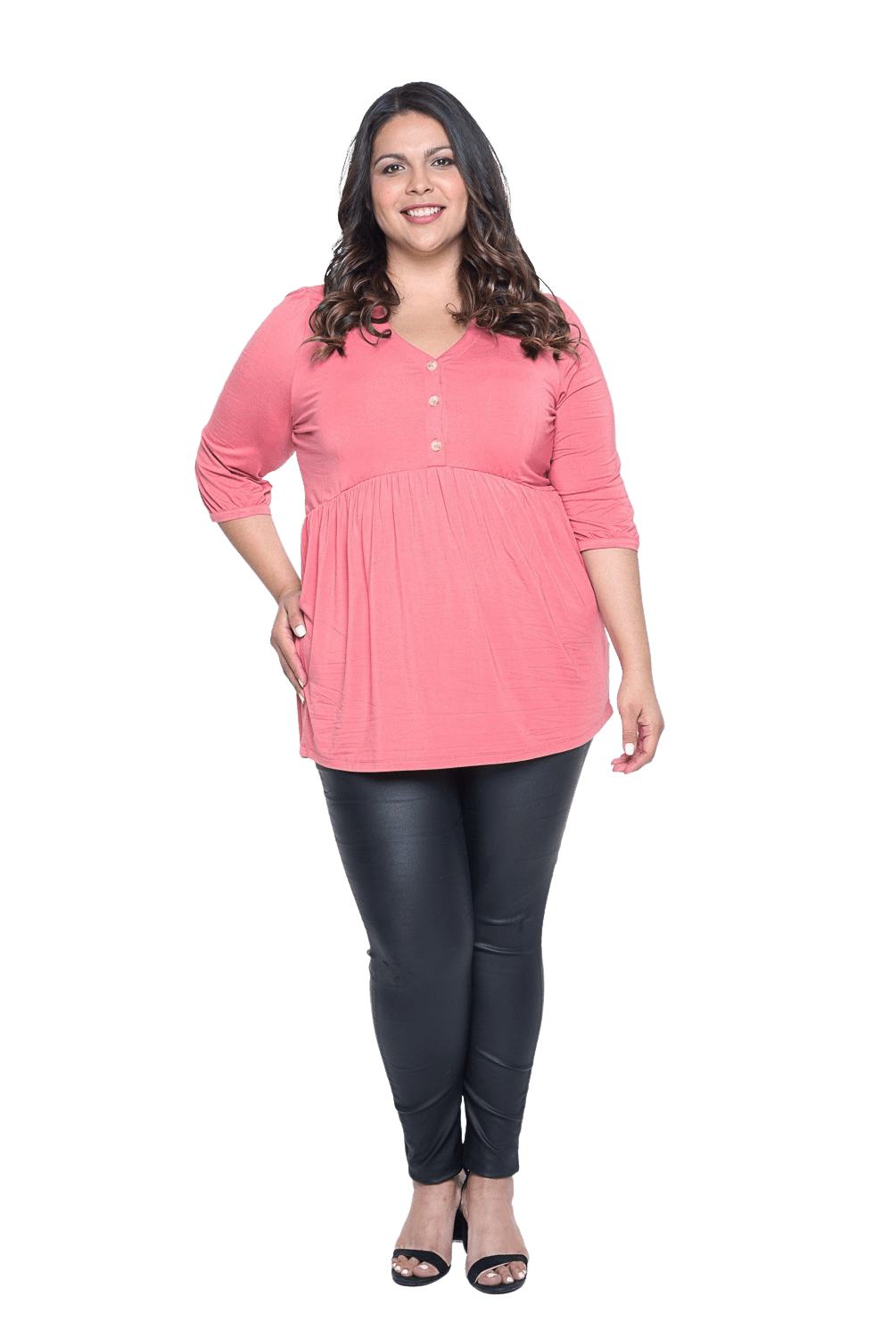 Curvy model facing camera wearing pink, mid-length sleeved top. Features button up v-neckline and peplum tier under bust. Dylan available in sizes 6-26