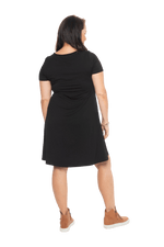 Model facing the back wearing black, short sleeved, knee length, A-line dress. Features rounded neckline. Emma available in sizes 6-18