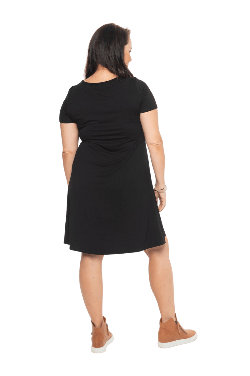 Model facing the back wearing black, short sleeved, knee length, A-line dress. Features rounded neckline. Emma available in sizes 6-18