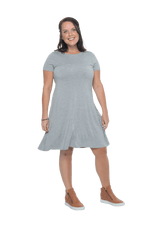 Model facing camera wearing grey, short sleeved, knee length, A-line dress. Features rounded neckline. Emma available in sizes 6-18