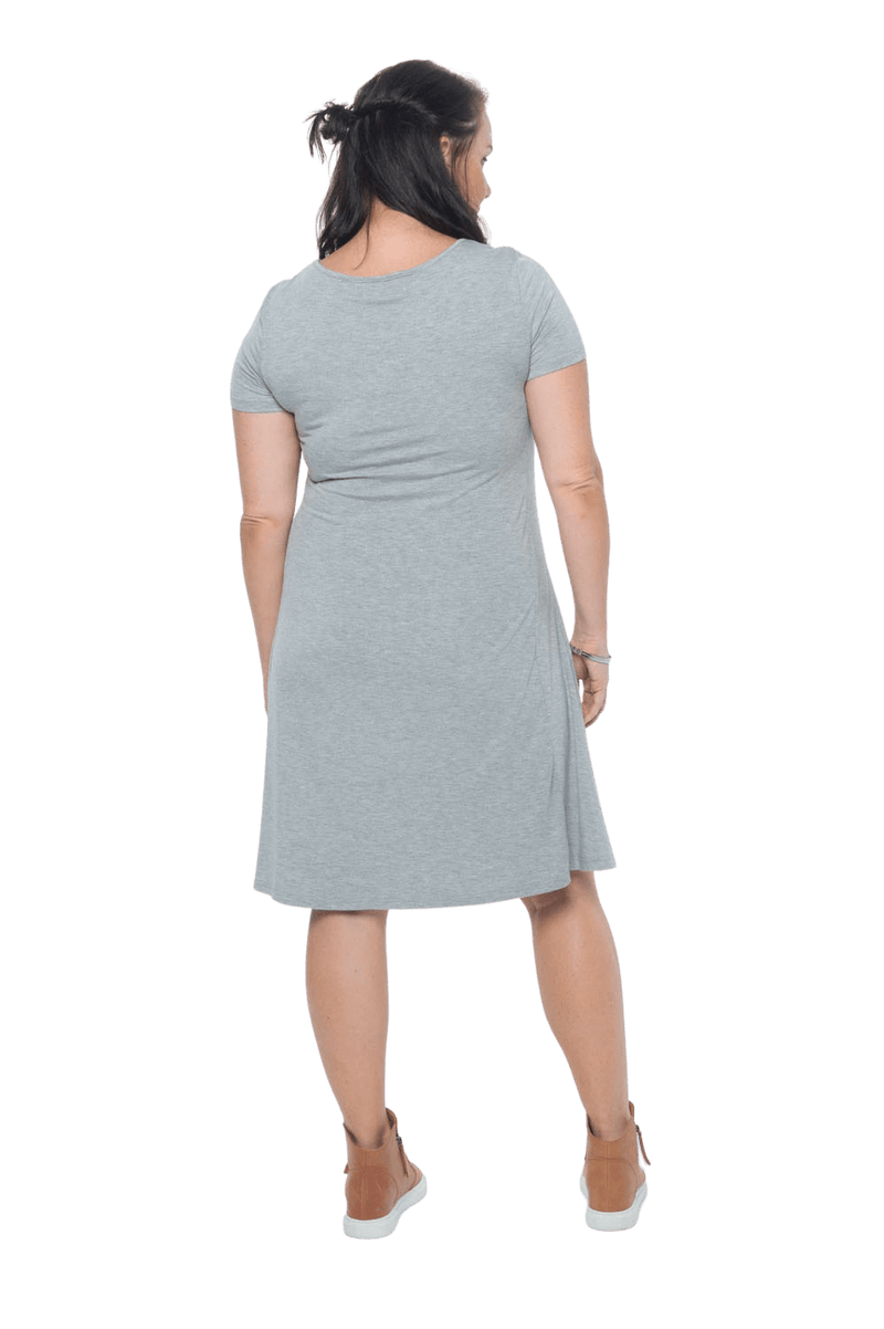 Model facing the back wearing grey, short sleeved, knee length, A-line dress. Features rounded neckline. Emma available in sizes 6-18