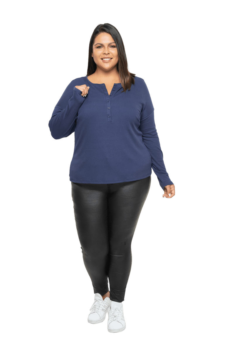 Curvy model facing camera wearing navy blue, long sleeved henley top, slightly unbuttoned. Features button front and dropped shoulder. Hunter available in sizes 6-26