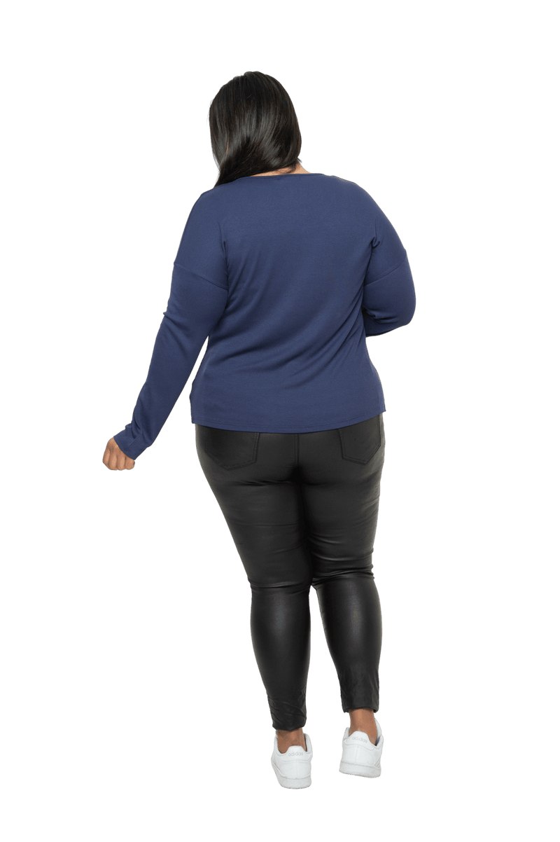 Curvy model facing the back wearing navy blue, long sleeved henley top. Features button front and dropped shoulder. Hunter available in sizes 6-26