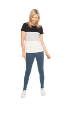 Petite model facing camera wearing colour blocked, short sleeved tee. Colour block is black in top third, grey & white stripe in middle third, white in bottom third. Features rounded neckline. Jamie available in sizes 6-26