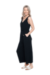 Petite model the side camera wearing black sleeveless, ankle-length jumpsuit, featuring crossover neckline, waist belt and pockets. Jesse available in sizes 6-26