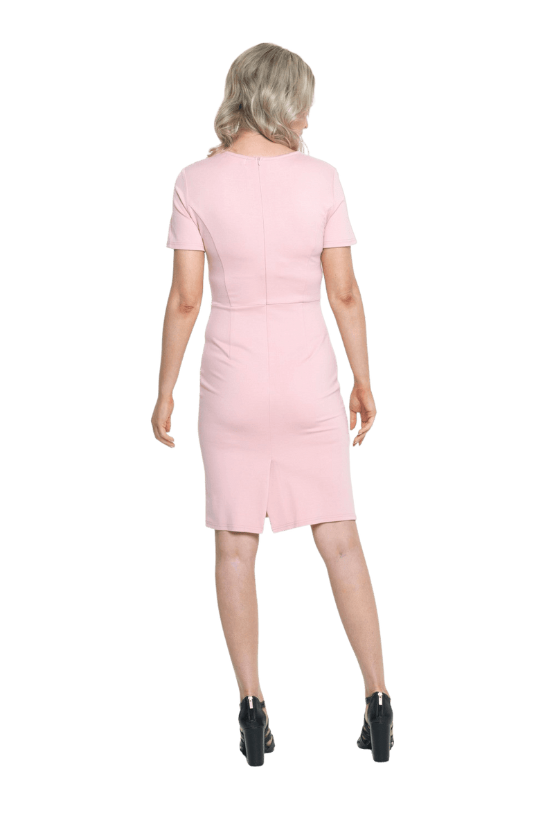 Petite model facing the back wearing pink dress, featuring rounded neckline, back zip and an elegant, fitted silhouette. Juliet available in sizes 6-18