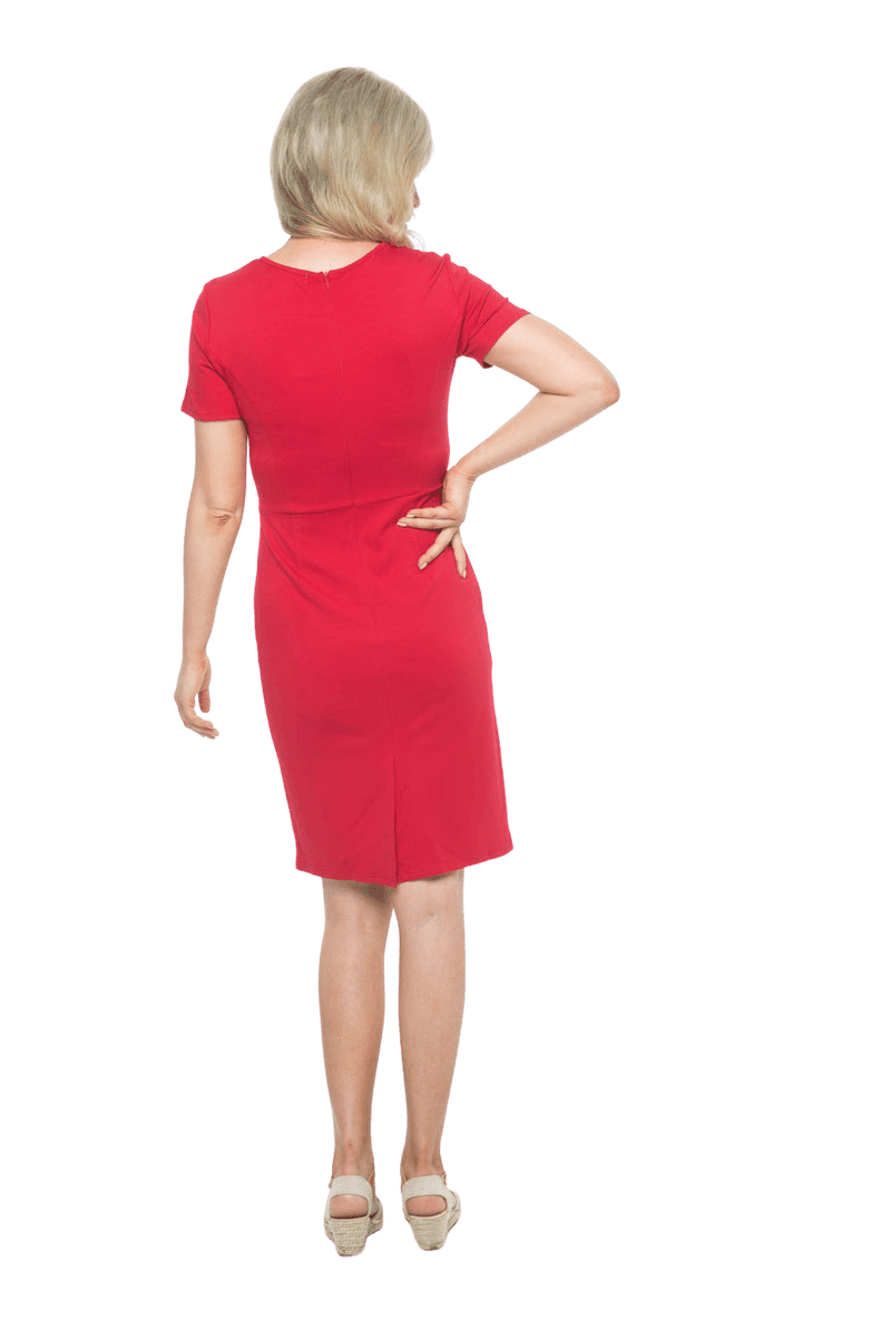 Petite model facing the side wearing red dress, featuring rounded neckline, back zip and an elegant, fitted silhouette. Juliet available in sizes 6-18